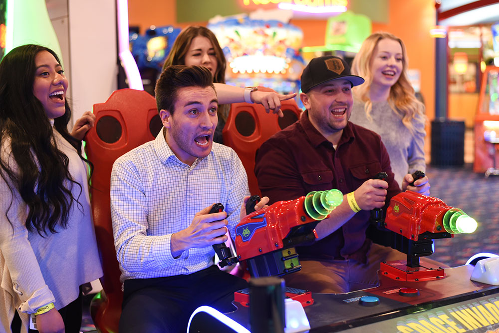 Group Playing Spaced Invaders Arcade Game