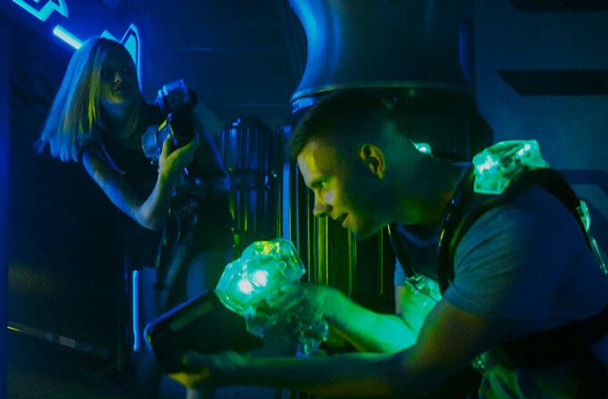 Girl and guy stealth playing Laser Tag