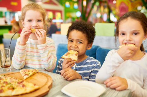Three kids eating pizza